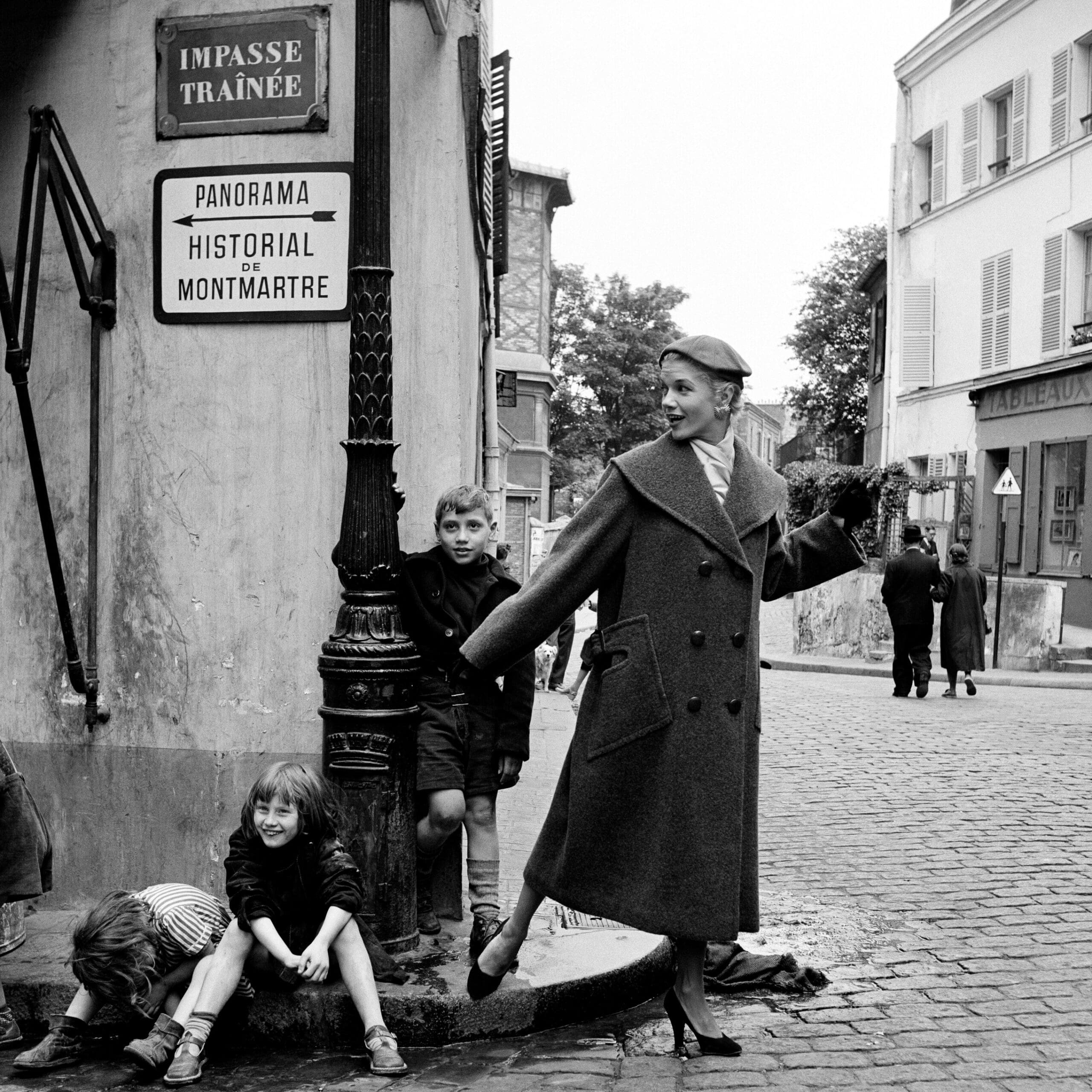 Marilyn Stafford. Model in ready-to-wear with children, Montmartre, Paris, c1955. Silver gelatin print. Courtesy of the Marilyn Stafford Collective