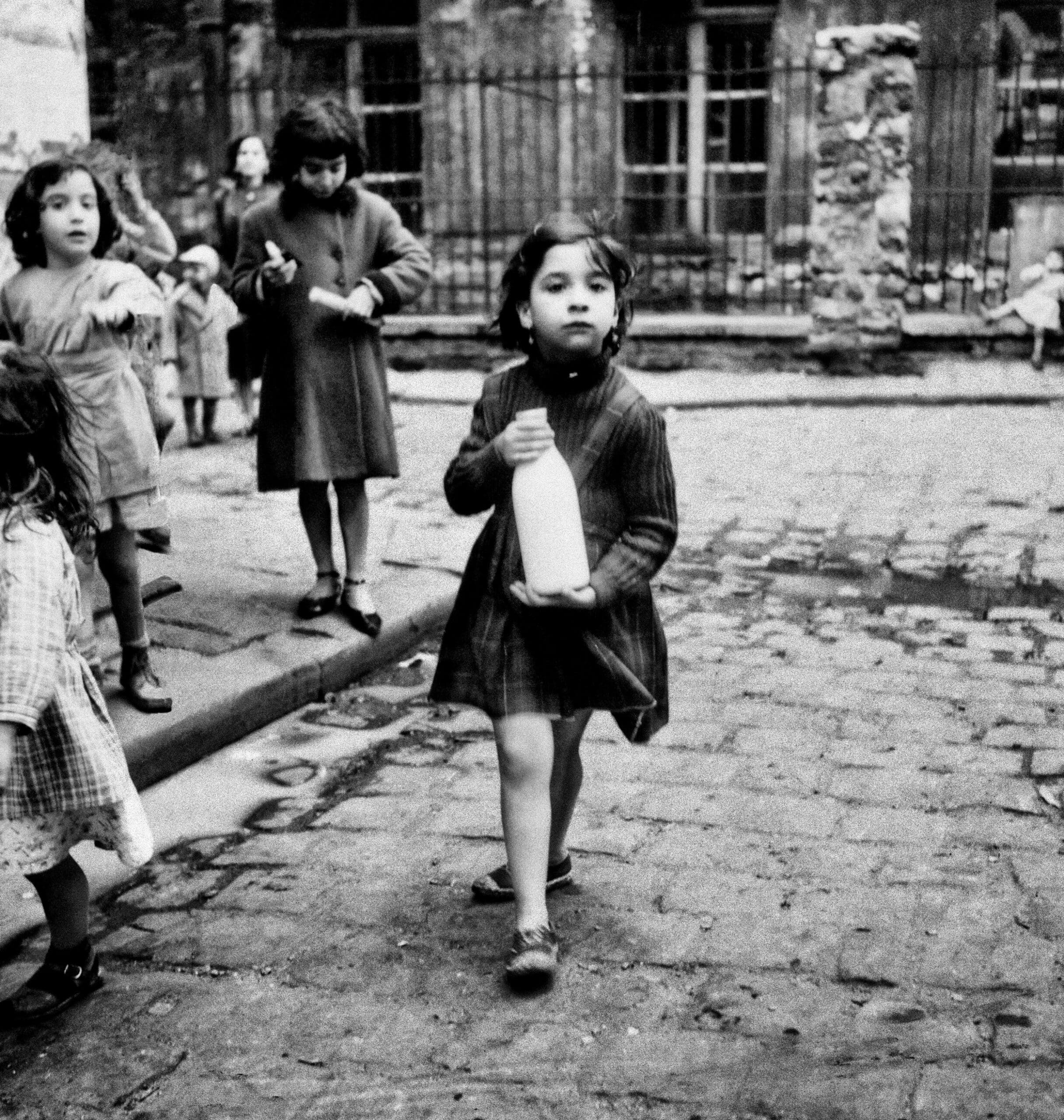 Marilyn Stafford. Girl with milk bottle, Cité Lesage-Bullourde, Paris, c1950. Silver gelatin print. Courtesy of the Marilyn Stafford Collective.