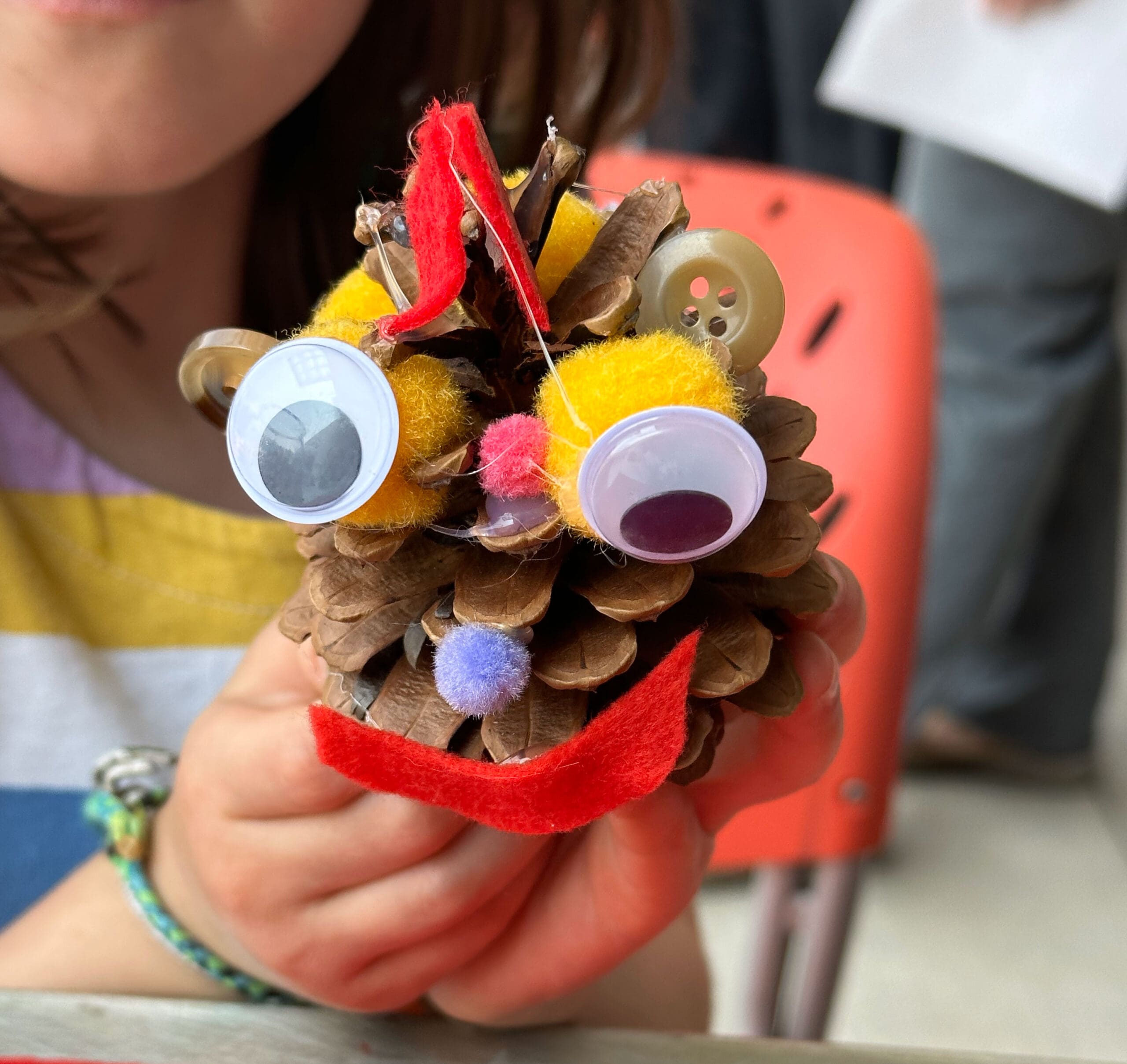 A child holding a toy bug they just made.