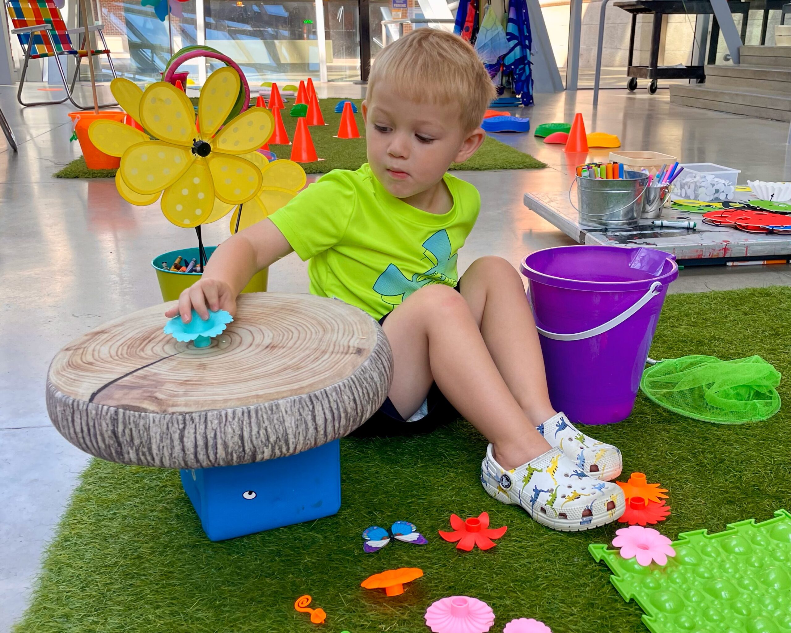 A child in a green shirt playing in the Akron Art Museum