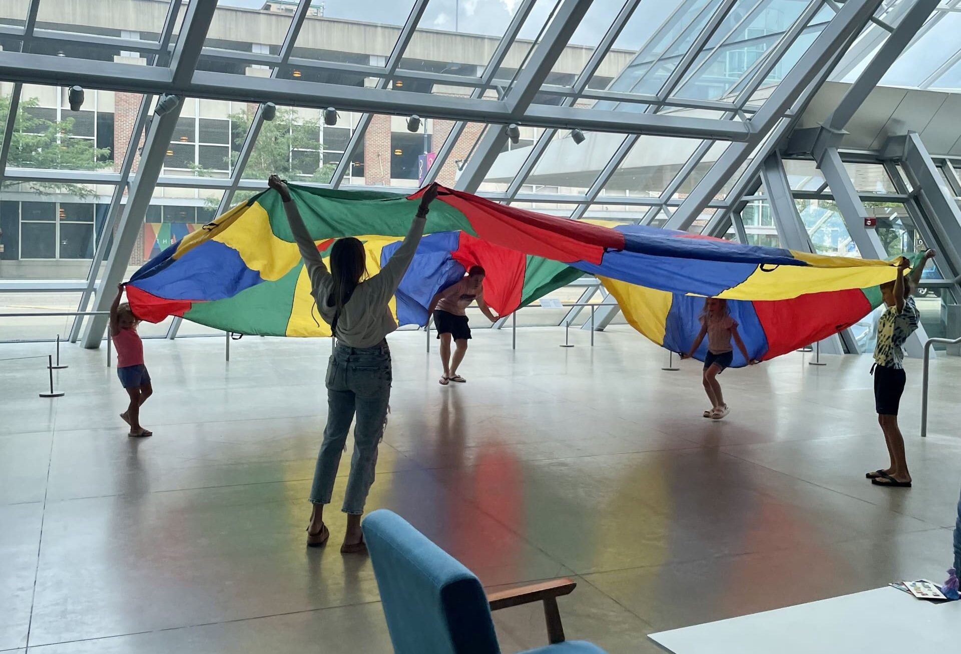 Children playing with a large piece of rainbow fabric